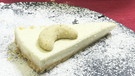 Eine cremiges Stück Torte mit Pannacotta-Füllung, auf dem ein Vanillekipferl drapiert ist. | Bild: BR