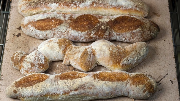 Brote liegen auf einem Backblech. | Bild: mauritius images / Klaus Wagenhäuser / imageBROKER