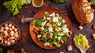 Ein klassischer Caesar Salad mit Parmesan und Brot auf einem Teller angerichtet. | Bild: mauritius-images