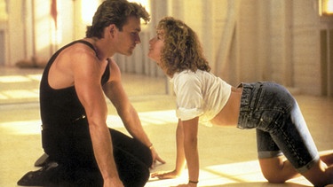 Filmszene aus "Dirty Dancing" in der Johnny und Baby auf dem Boden knien. | Bild: picture-alliance/dpa