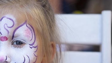 Ausschnitt eines Fotos, das das geschminkte Gesicht eines kleinen Mädchens zeigt | Bild: picture-alliance/dpa