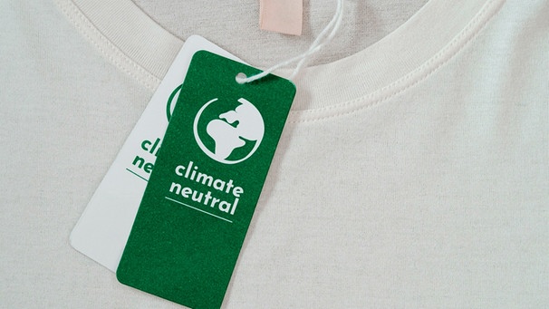 Ein T-Shirt wird beworben mit dem Wort "klimaneutral" | Bild: mauritius images