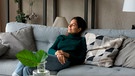 Eine Frau sitzt auf einem Sofa in einem Wohnzimmer
| Bild: mauritius images/ Aleksandr Davydov / Alamy / Alamy Stock Photos