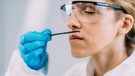 Chemikerin riecht in einem Labor an einer Vanilleschote | Bild: mauritius images / Science Photo Library / Microgen Images