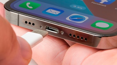 Hand steckt USB-C-Ladekabel in ein Smartphone | Bild: mauritius images / Yalcin Sonat / Alamy / Alamy Stock Photos