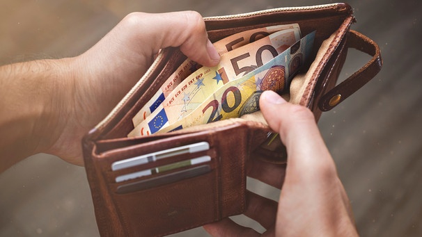 Mann hat einen Geldbeutel mit Euro-Scheinen in der Hand | Bild: mauritius images / EyeEm / Rene Schmidt