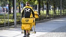 Ein Postbote fährt auf einem Fahrrad durch München | Bild: dpa/picture alliance