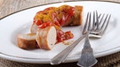 Eine Currywurst und Besteck liegen auf einem Teller | Bild: mauritius images