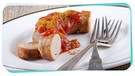 Eine Currywurst und Besteck liegen auf einem Teller | Bild: mauritius images / Jörg Beuge / Alamy / Alamy Stock Photos / Montage: BR