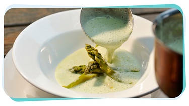 Schöpflöffel mit feiner schaumiger Suppe, dazu grüne Spargelspitzen | Bild: mauritius images / Hubertus Blume / Alamy / Alamy Stock Photos
