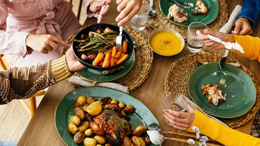 Freunde bei einem Festmahl mit Gänsebraten, Kartoffeln und Suppe | Bild: mauritius images/ Westend61 RF
