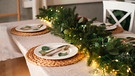 Gute Ideen zum Dekorieren: Einfach Tannenzweige mit Lichterkette und ein paar Zweigen Eukalylptus auf dem Tisch ausbreiten | Bild: mauritius images/ Nina Hilitukha / Alamy / Alamy Stock Photos