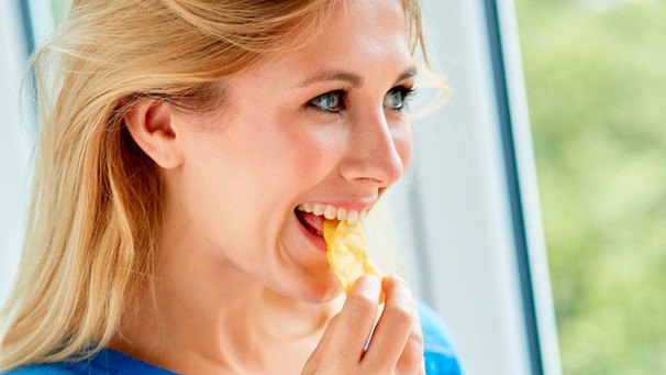Eine junge Frau isst Chips | Bild: mauritius images / Chris Rout / Alamy / Alamy Stock Photos
