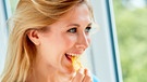Eine junge Frau isst Chips | Bild: mauritius images