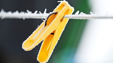 Eine gelbe Wäscheklammer ist gefroren. | Bild: colourbox.com