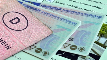 Alter rosa und zwei Check-Karten Führerscheine liegen neben einem Kugelschreiber | Bild: mauritius images / Pitopia / Joachim B. Albers