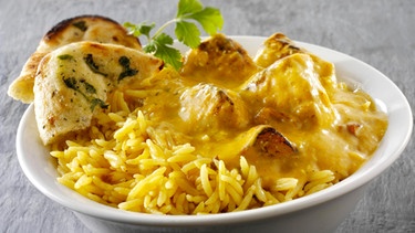 Curry mit Reis und Naan Brot in einer Schale | Bild: mauritius-images
