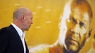 Creedence Clearwater Revival im Film: Schauspieler Bruce Willis blickt auf sein Konterfei auf einem Plakat für den Film "Stirb langsam 4.0". | Bild: picture-alliance/dpa