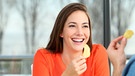 Eine junge Frau isst Kartoffelchips | Bild: mauritius images / Antonio Guillem Fernández / Alamy / Alamy Stock Photos