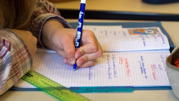 Ein Kind schreibt mit der linken Hand. | Bild: picture-alliance/dpa