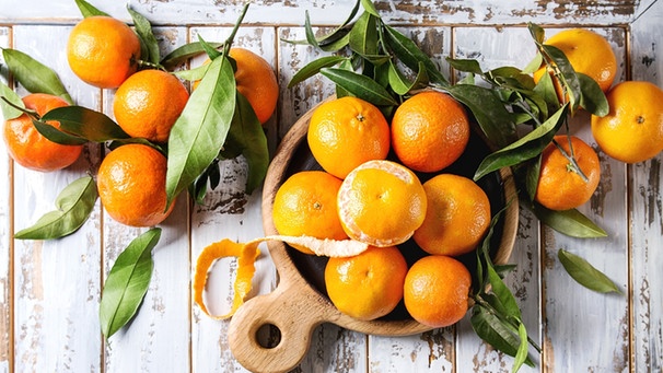Mehrere Mandarinen liegen auf einem Tisch.  | Bild: mauritius-images
