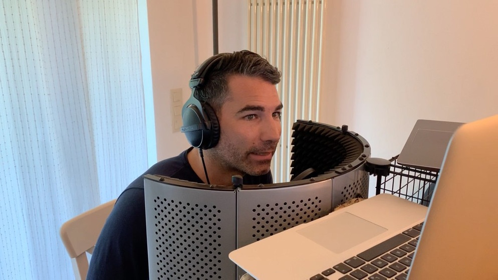 Marcus Fahn beim Überraschungsanruf mit einer Hörerin, in dem kleinen Studio bei sich daheim an einem Tisch vor technischen Gerätschaften sitzend. | Bild: BR