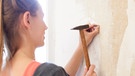 Eine Frau renoviert ihre Wohnung. | Bild: picture-alliance/dpa