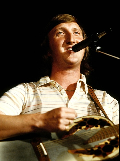 Mike Krüger steht mit Gitarre hinter einem Mikrofon und singt. | Bild: picture-alliance/dpa