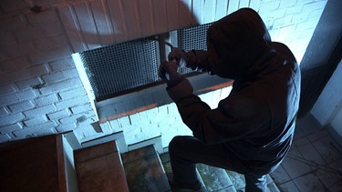 Einbrecher macht sich am Kellerfenster zu schaffen | Bild: Imago/Jochen