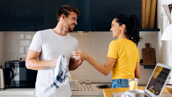 Ein Pärchen wäscht gemeinsam in der Küche ab. | Bild: mauritius-images