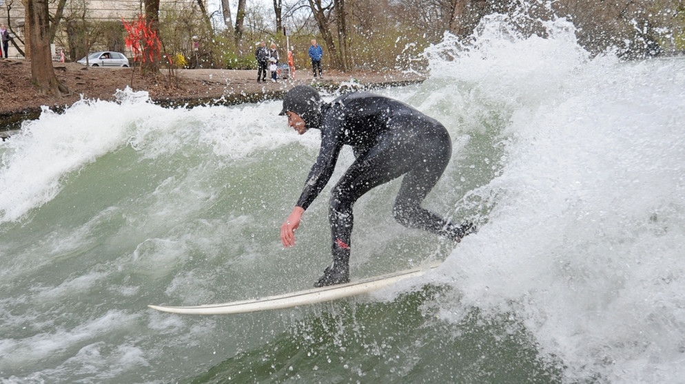 Mann surft auf der Eisbachwelle in München | Bild: picture-alliance/dpa