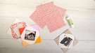 Auf einem Brett liegt Origami-Papier, ein Klebestift sowie fertig gebastelte Papierrahmen. | Bild: Bogdan Kramliczek