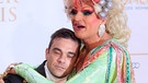 Robbie Williams schmiegt sich an Olivia Jones falschen Busen beim Deutschen Radiopreis 2012 | Bild: picture-alliance/dpa