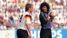 Rudi Völler und der kolumbische Torwart Jose Rene Higuita auf dem Spielfeld. | Bild: picture-alliance/dpa