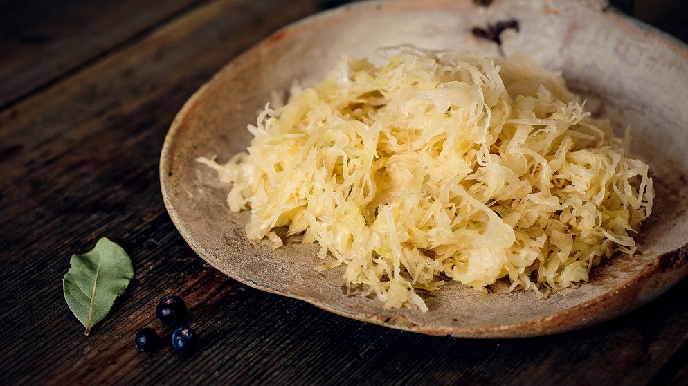 Sauerkraut auf Teller auf Holztisch | Bild: mauritius-images