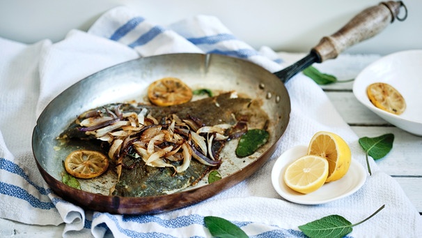 Fisch in Pfanne mit Zwiebeln und Zitrone | Bild: mauritius images / foodcollection