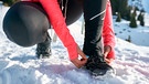 Frau schaut auf ihre Schuhe im Schnee | Bild: mauritius-images