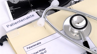 Eine Patientenakte liegt auf dem Tisch eines Arztes. | Bild: picture-alliance/dpa