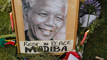 Südafrika: Ein gerahmtes Foto des verstorbenen, südafrikanischen Ex-Präsidenten Nelson Mandela auf Blumen | Bild: picture-alliance/dpa