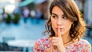 Frau deutet an, man möge bitte das Geheimnis für sich behalten, mit Finger an ihrem Mund | Bild: mauritius images / Andrii Iemelianenko / Alamy / Alamy Stock Photos