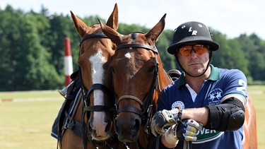 Der Schauspieler Heino Ferch mit zwei Polo-Pferden | Bild: picture-alliance/dpa
