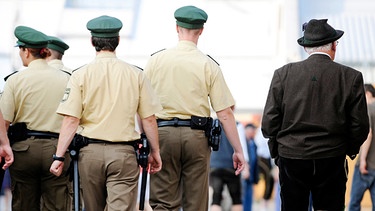 Symbolbild: Polizeibeamte gehen neben einem Mann in Tracht auf dem Oktoberfest 2009 | Bild: Steffi Loos/dapd