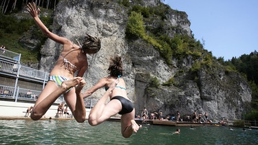 Zwei Schülerinnen springen ins Becken des Felsenbads Pottenstein | Bild: picture-alliance/dpa