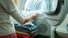 Person nimmt Wäsche aus einem Wäschetrockner | Bild: mauritius images  Aleksandra Suzi  Alamy  Alamy Stock Photos