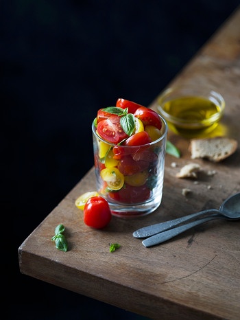 Tomatensalat in einem Glas steht auf einem Holztisch | Bild: mauritius-images