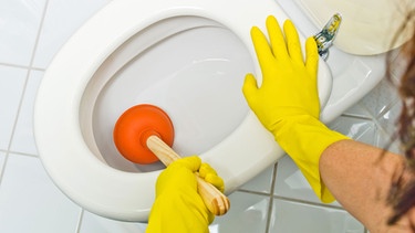 Frau reinigt verstofte Toilette | Bild: colourbox.com