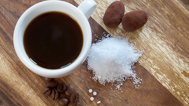 Tasse Kaffee mit einem Häufchen Stevia daneben | Bild: picture alliance | Anne-Kathrin Pries / CHROMORANGE