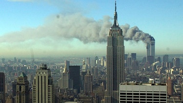 ARCHIV - 11.09.2001, USA, New York: Rauchschwaden ziehen über die Skyline von New York City, nachdem zwei entführte Flugzeuge in die Zwillingstürme des World Trade Centers geflogen waren. | Bild: dpa-Bildfunk/Patrick Sison