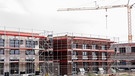 Häuser stehen eingerüstet auf einem Baufeld am Stadtrand von Köln | Bild: picture-alliance/dpa