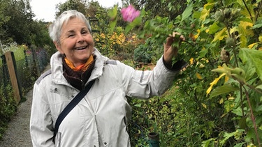 Roswitha Spießl freut sich über Blumen und ärgert sich über Immobilienspekulanten, die Kleingärten zerstören. | Bild: BR / Joseph Berlinger